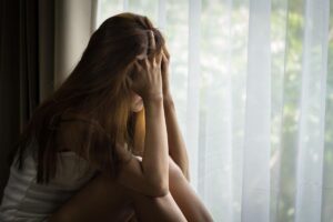 teen sitting by bedroom window in distress in need of tips for morning anxiety