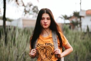 moody teen girl wearing orange top